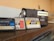 Three vintage audio cassette tapes in various colors are placed on a wooden surface next to a retro-style radio. The cassettes and radio create a nostalgic ambience.
