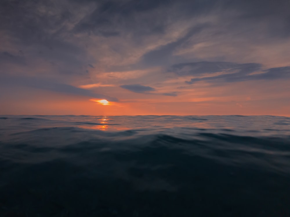body of water in horizon of sunset