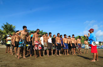 Instructor guiding a small group of students through a dive briefing on the beach.