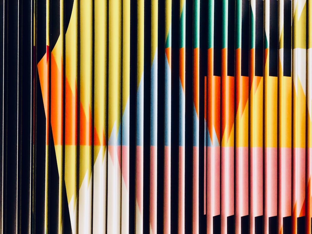 a large group of colored pencils sitting next to each other