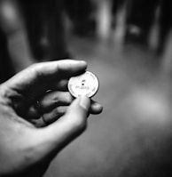 grayscale photography of person holding coin