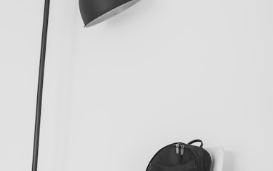 black lamp beside backpack on top of chair