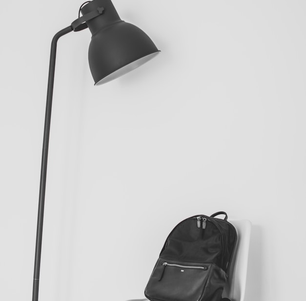 black lamp beside backpack on top of chair