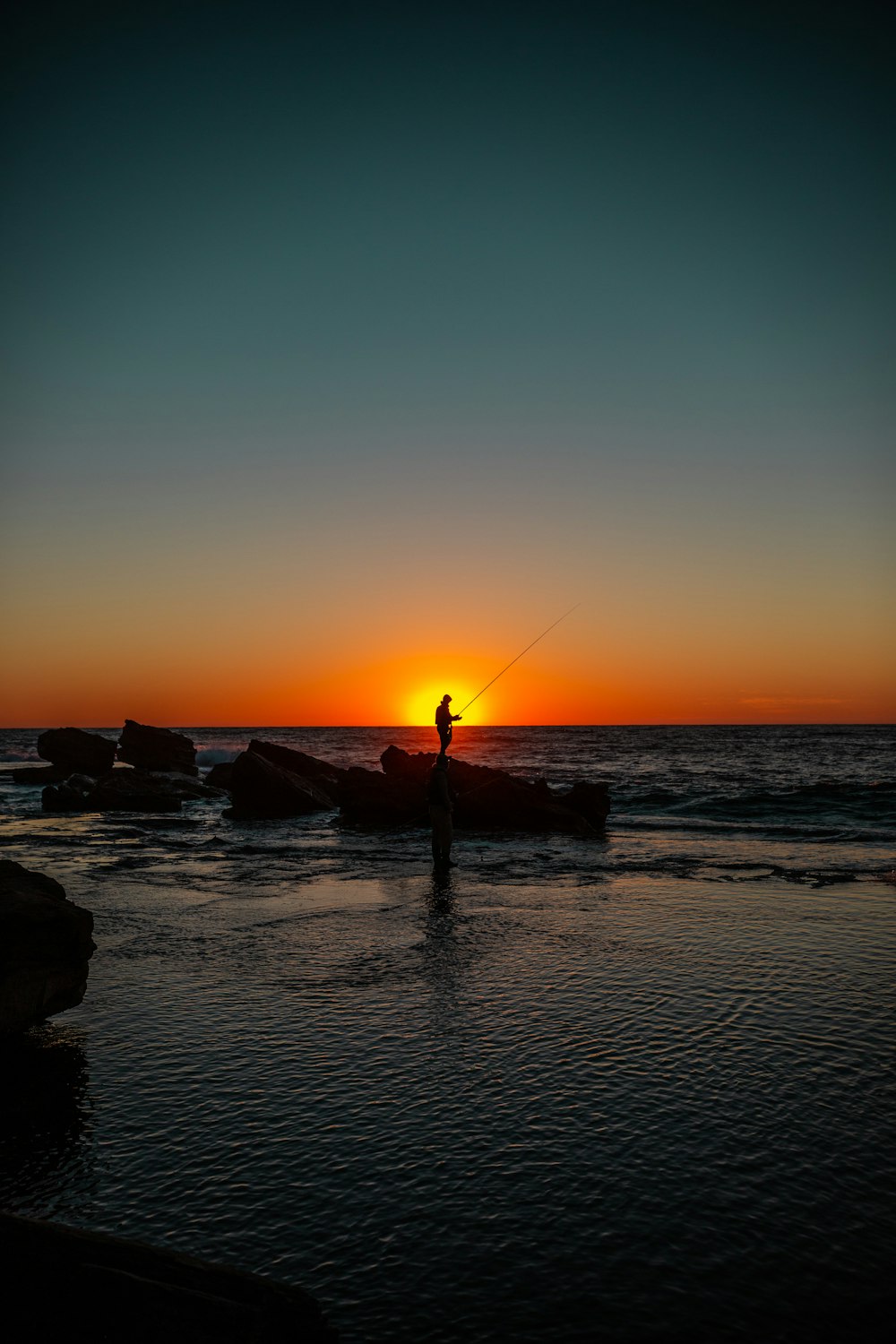 silhouette of man holding fishing rod