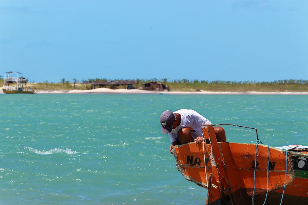 man on boat looking down on sea at daytime