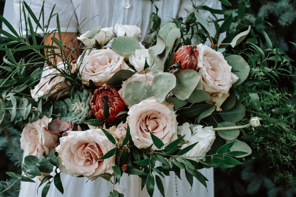 person holding bouquet of pink and red flowers