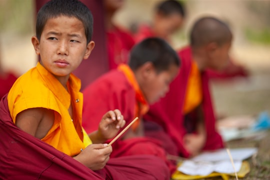 selective focus photography of boy sitting in round in Thimphu Bhutan