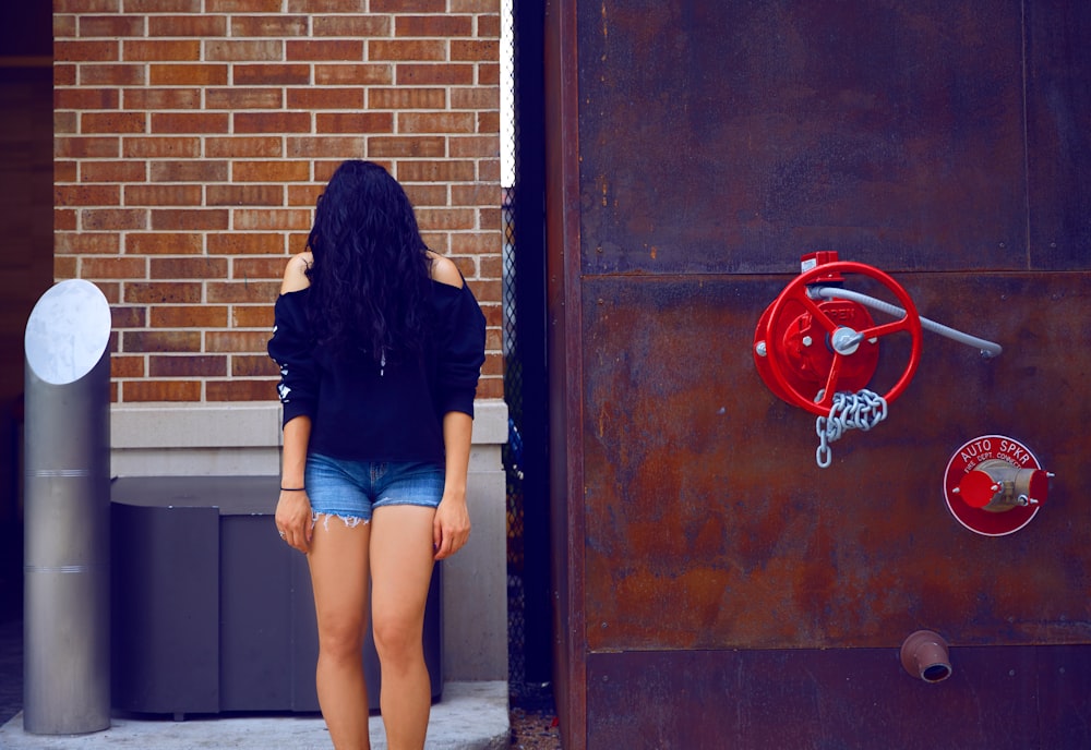 woman covered with hair standing beside building