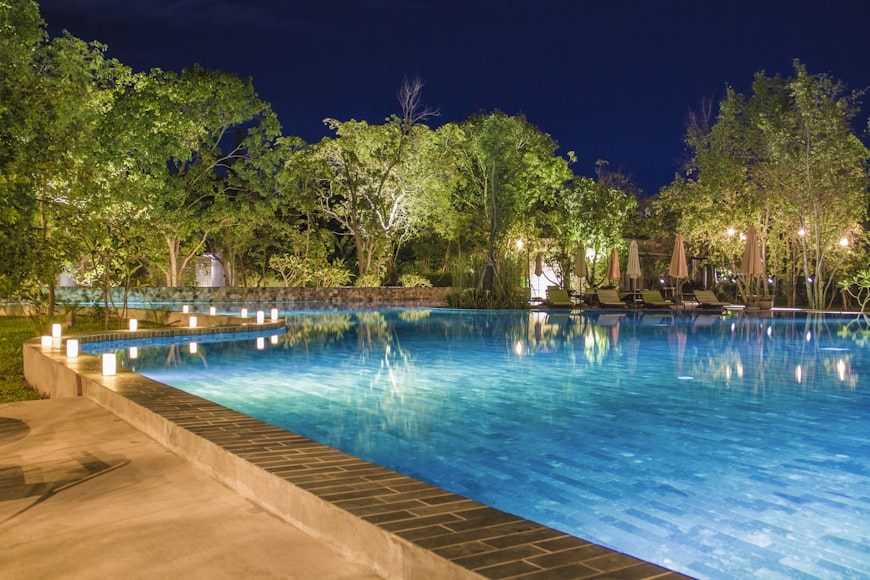 An image of a pool with outdoor lighting
