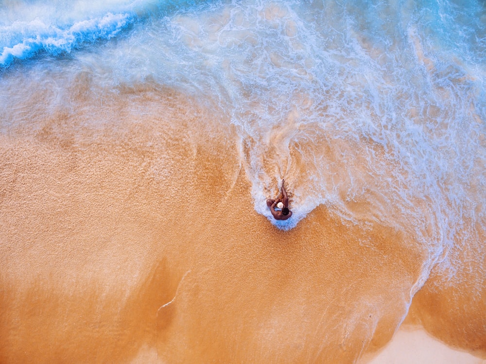 fotografia aerea di una persona seduta sul mare