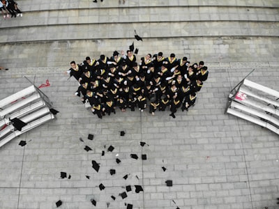 group of graduates throwing academic hats accomplished teams background