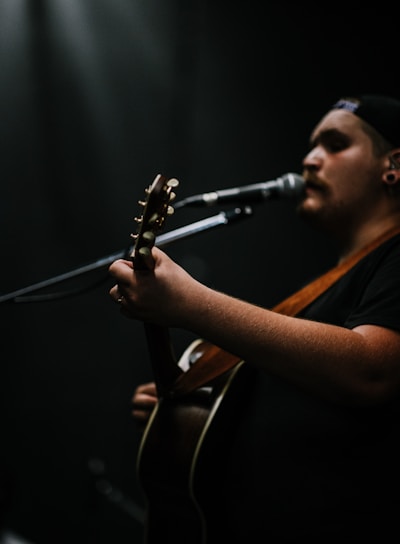 person playing guitar while singing