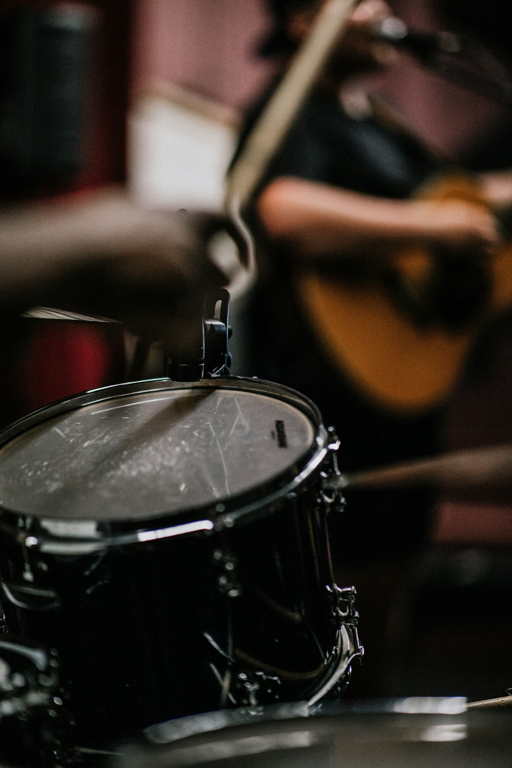 person playing guitar near drums