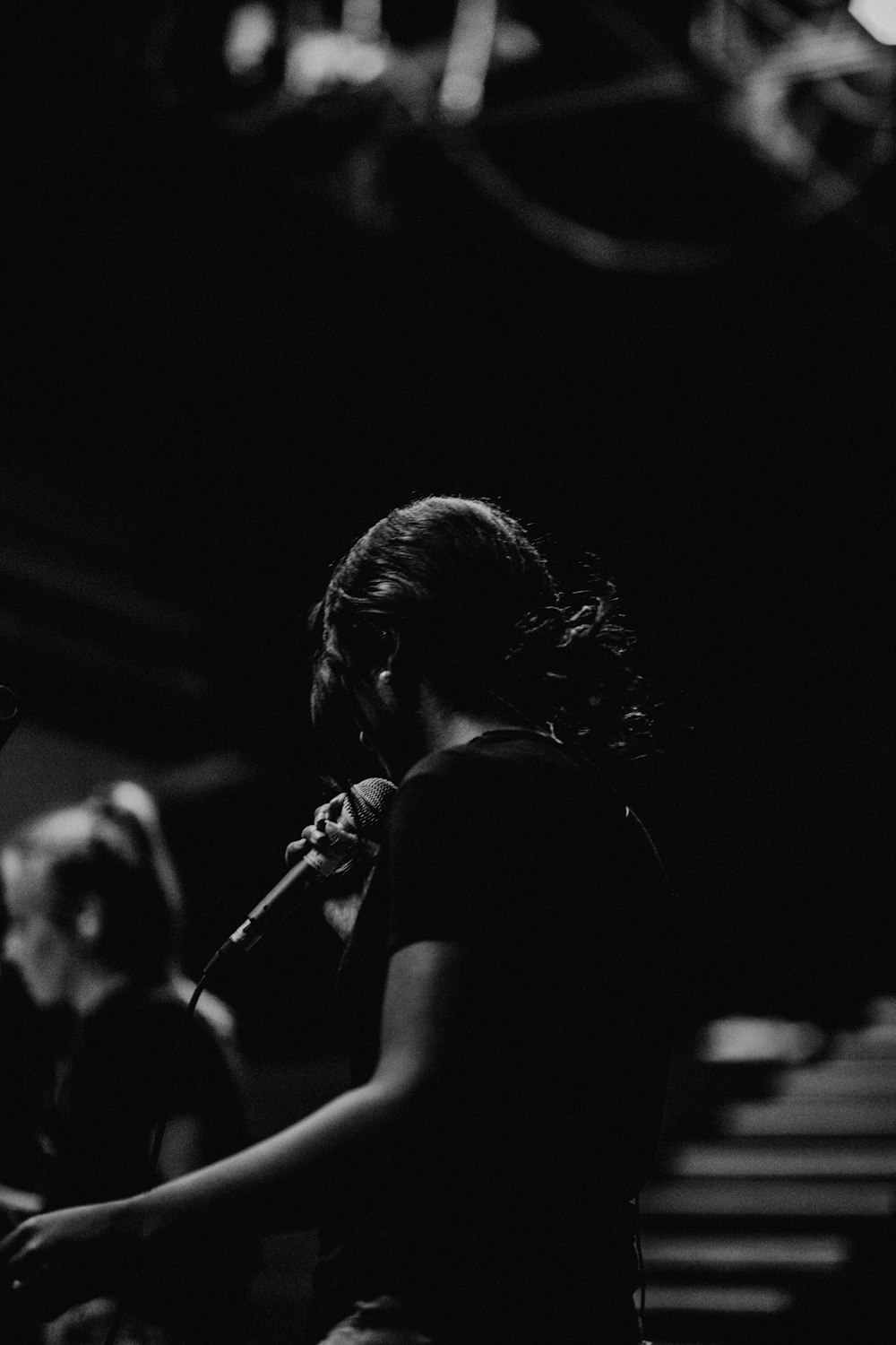 grayscale photography of person holding microphone