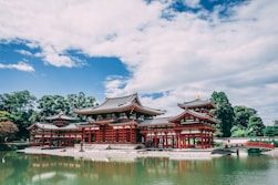 pagoda temple across body of water under blue cloudy sky