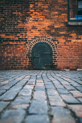 black metal door on brick wall