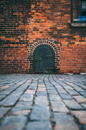 black metal door on brick wall