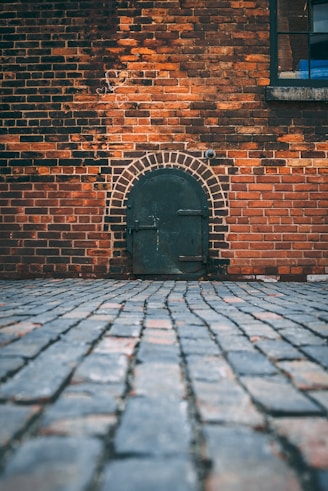 black metal door on brick wall