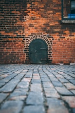 black metal door on brick wall