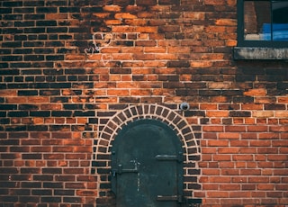 black metal door on brick wall