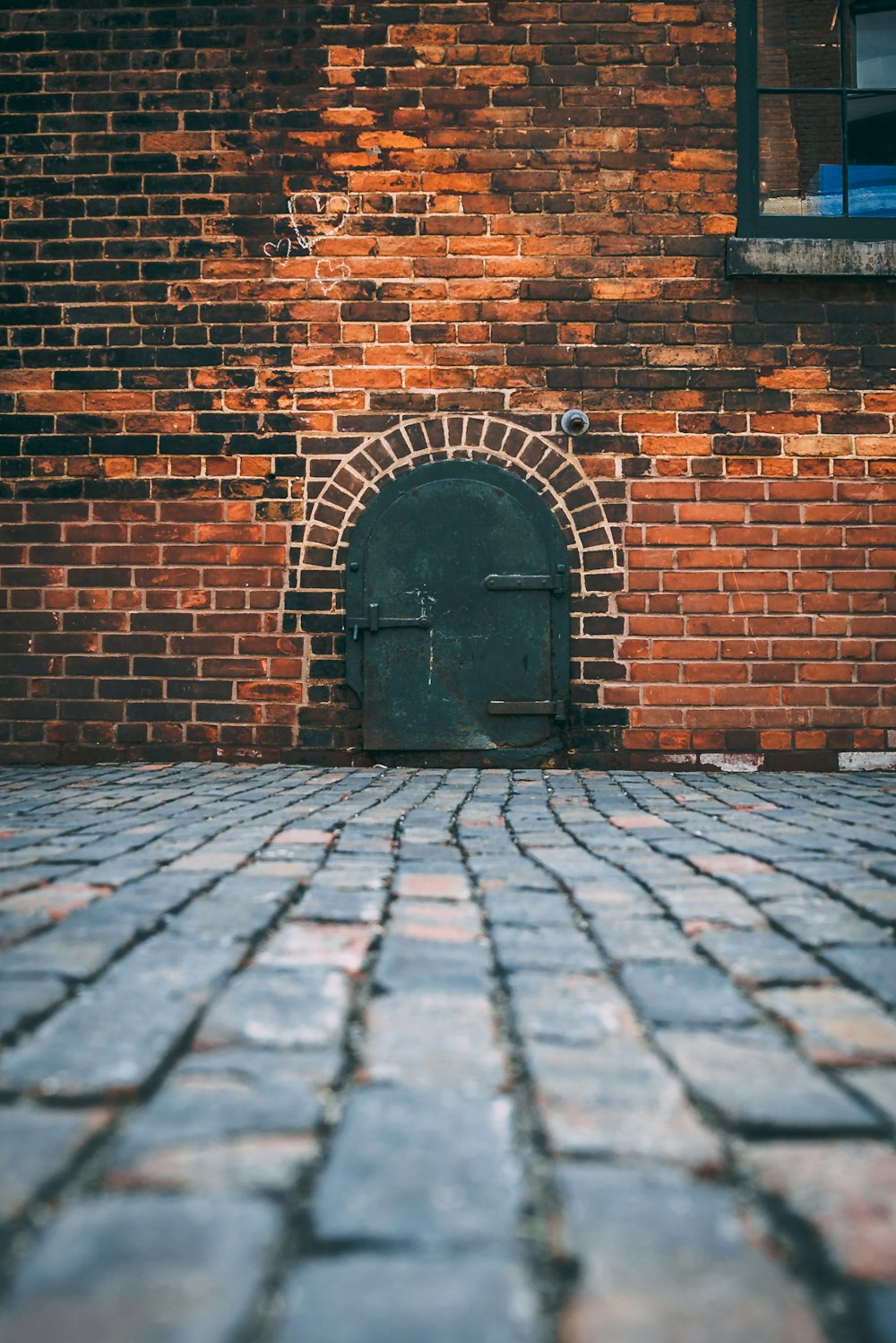 Porte en métal noir sur mur de briques