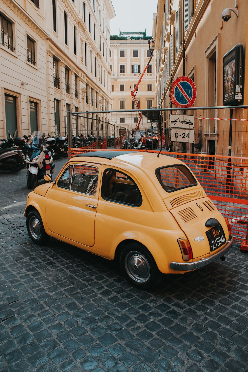 Orangefarbenes Auto im Käfer-Stil in der Nähe des Gebäudes geparkt