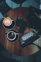 A minimalist wallet peeking out of a chic handbag on a café table with a cup of coffee.