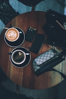 A wallet being placed into a stylish handbag on a cafe table.