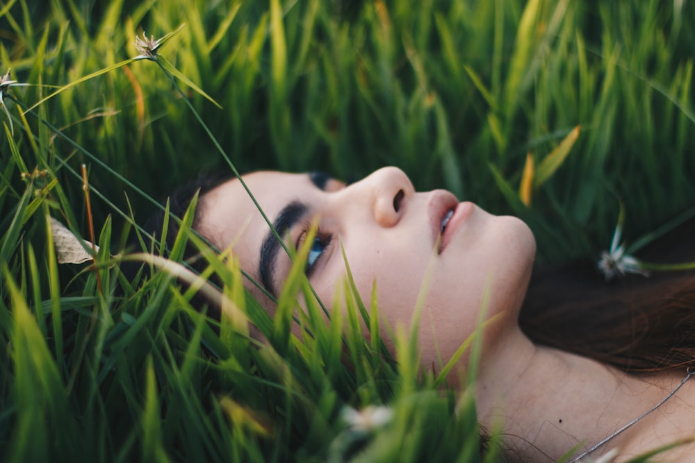 portrait photography of woman lying on grawss