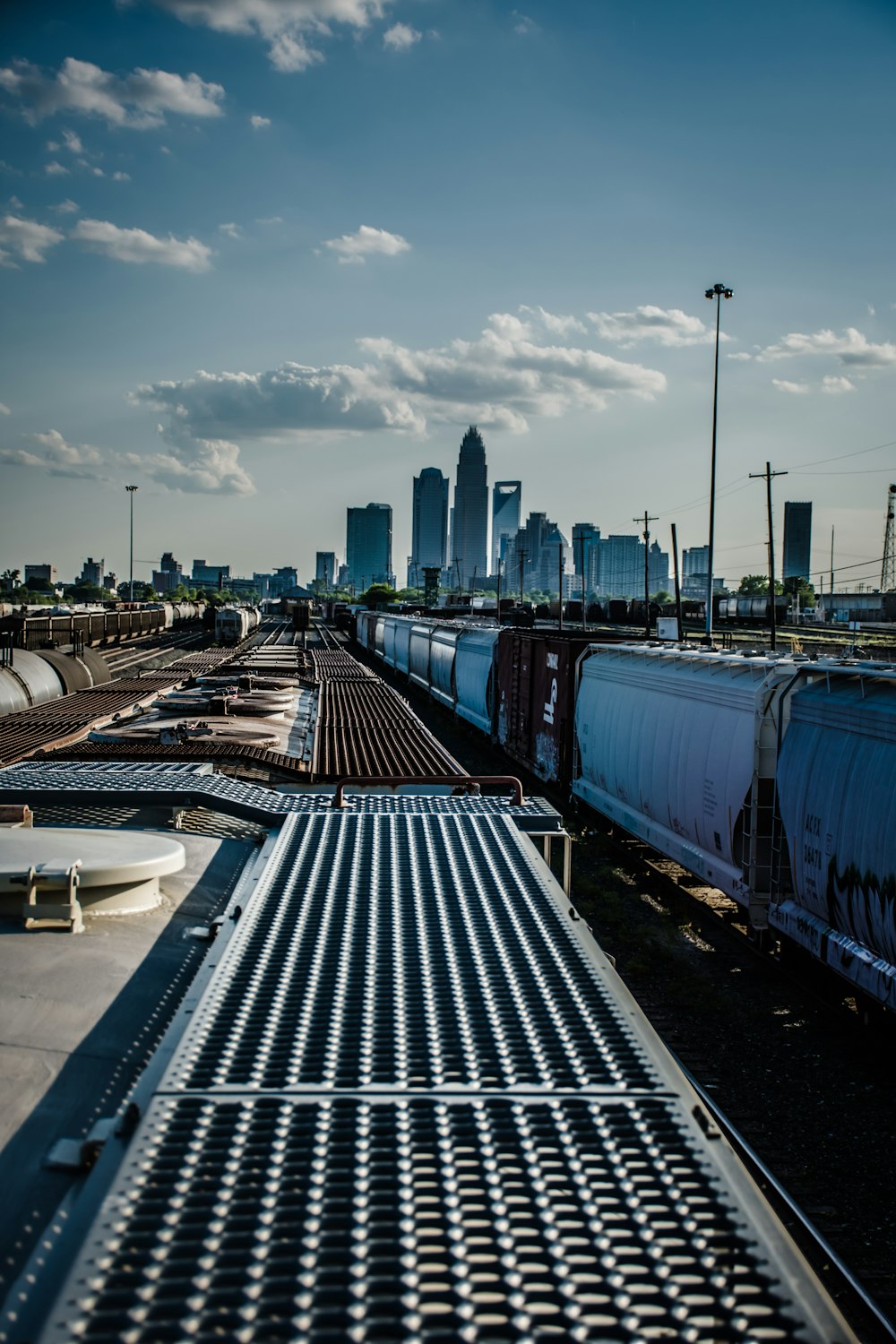 blue train viewing city with high-rise buildings under blue and white skies