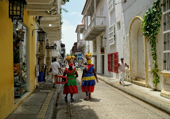 People walking on road between concrete houses during daytime — Cartagena, Colombia