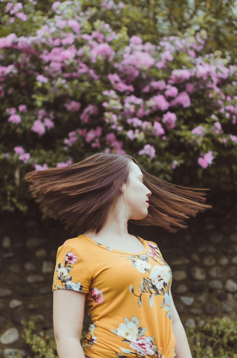 woman in orange floral crew-neck t-shirt while swinging head