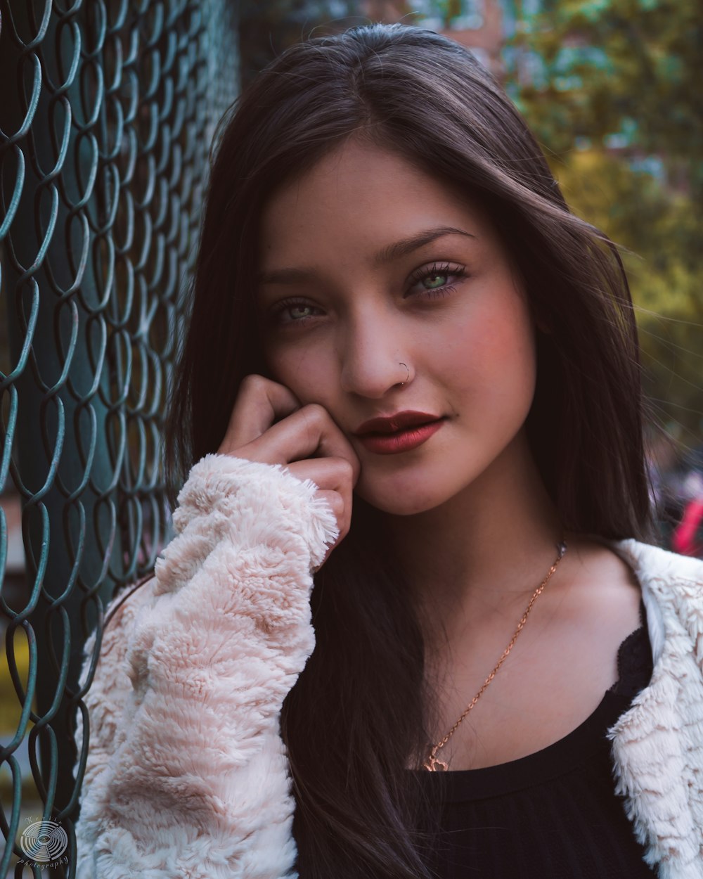 woman leaning on wire fence at daytime