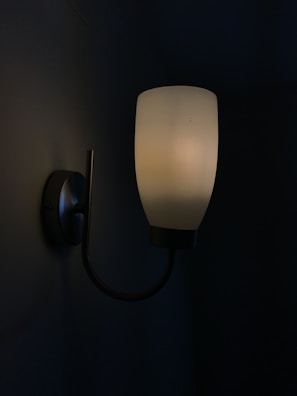 A modern LED wall sconce with clean lines brightening a hallway wall.