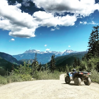 Quadricycle speeding along a rugged mountain trail in Monte Verde under clear blue skies.