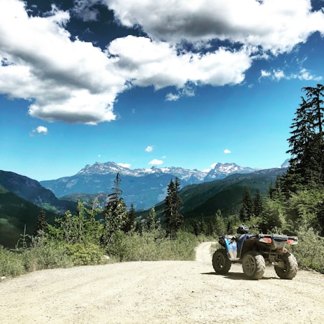 Quadricycle speeding along a rugged mountain trail in Monte Verde under clear blue skies.