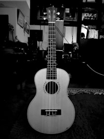 Close-up of hands strumming a ukulele with recipe cards and spices scattered nearby.