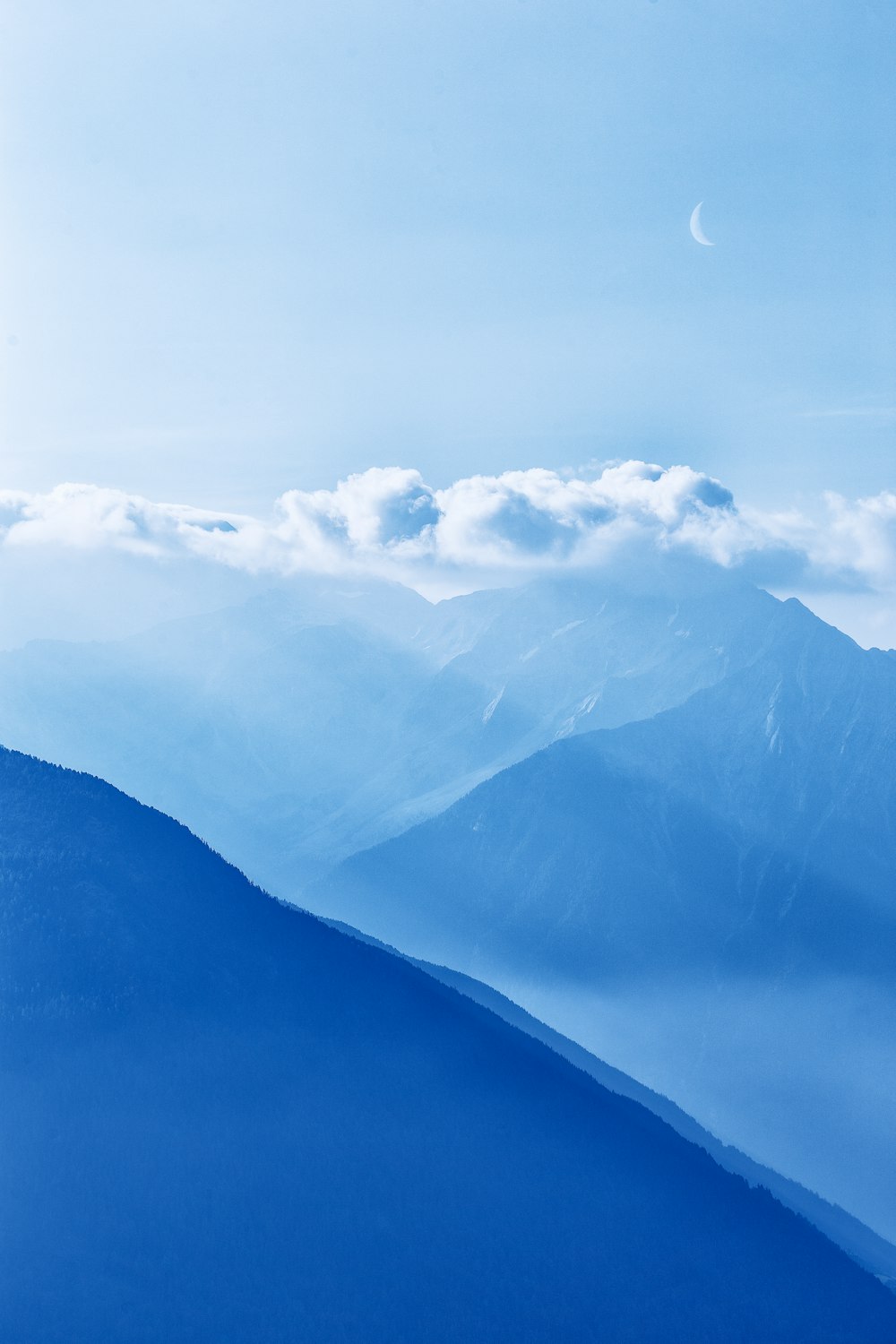 silhouette of mountains under cloudy sky