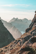 closeup photo of rocky mountain under blue and white sky