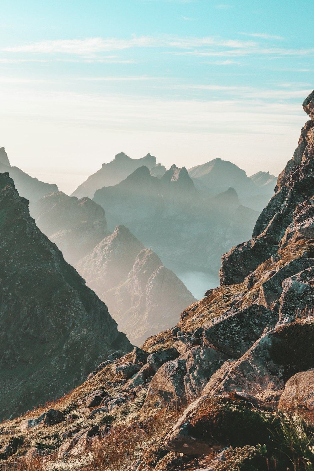 closeup photo of rocky mountain under blue and white sky