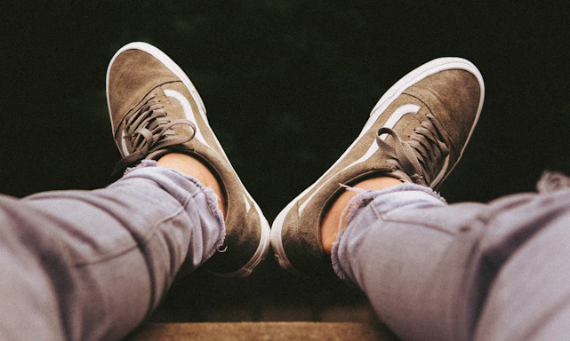 person in gray pants wearing pair of brown sneakers