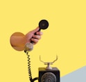 person holding black rotary telephone