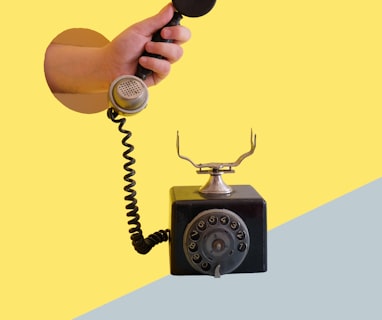 person holding black rotary telephone