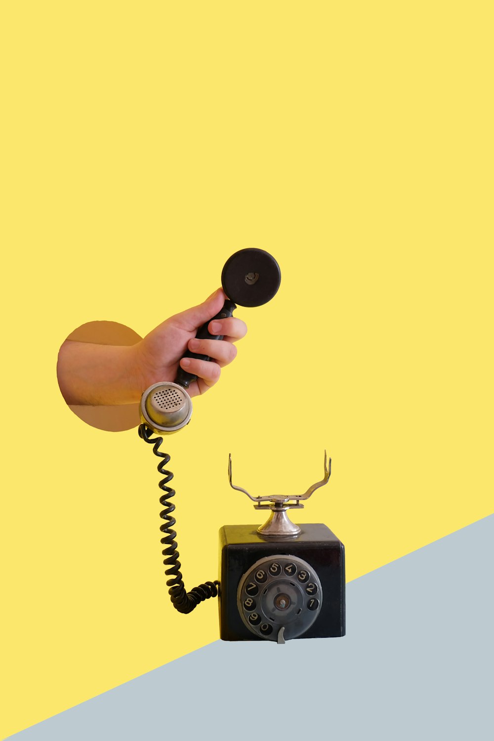 person holding black rotary telephone