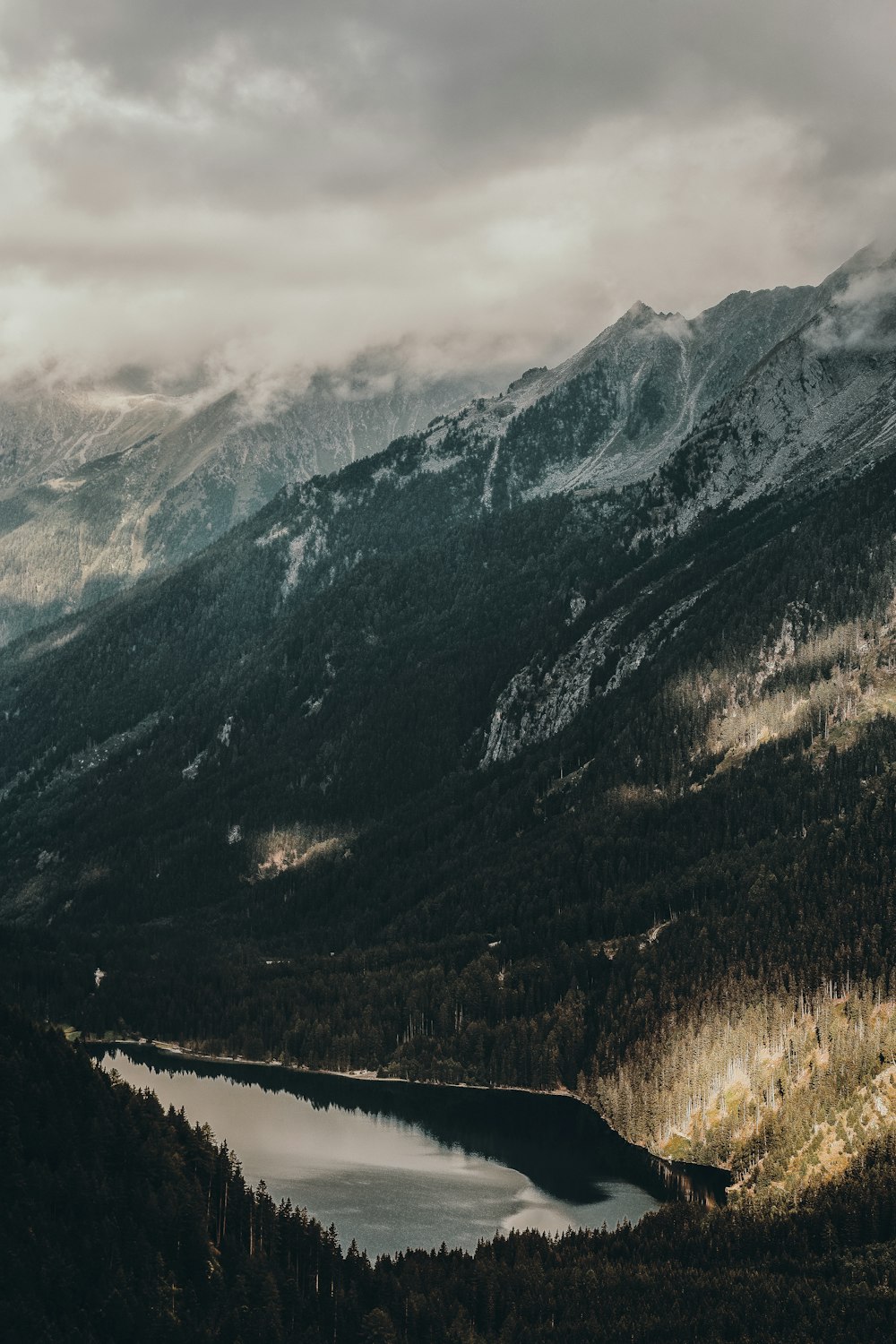 body of water between snow covered mountains