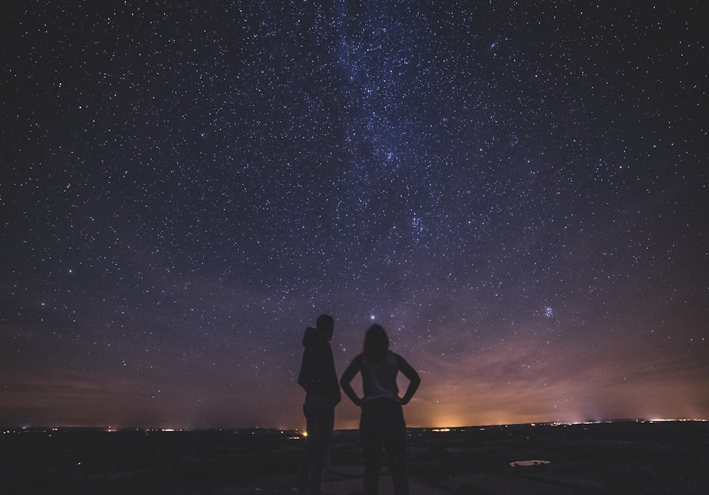 silhouette of people under milky way