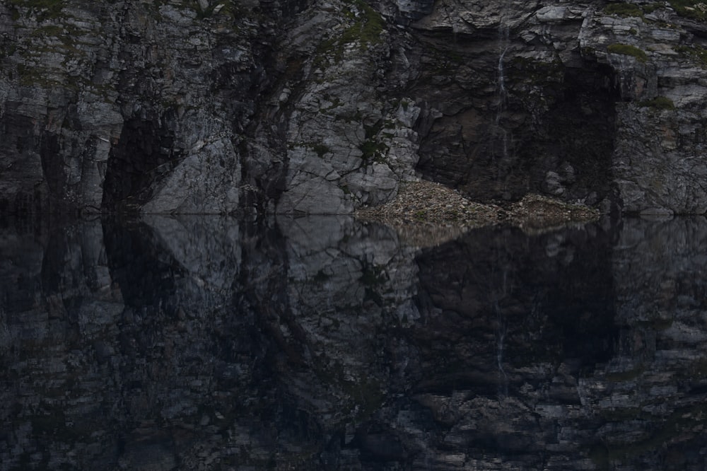 brown and gray cave with body of water