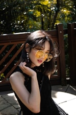 woman in black sleeveless top standing beside fence