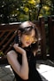 woman in black sleeveless top standing beside fence