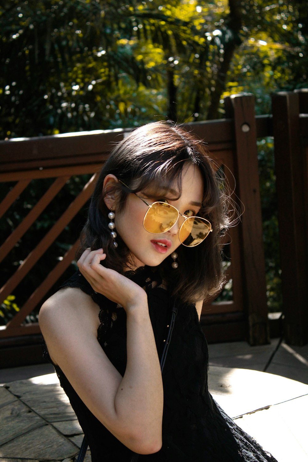 woman in black sleeveless top standing beside fence